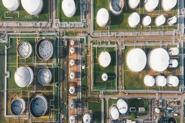 Aerial view morning time of petro chemical plant and oil refinery, power plant working with crude oil Storage tank at sunrise near mountain green environment concept