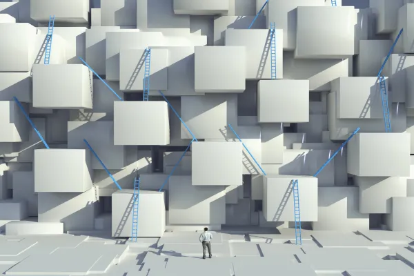 Caucasian man looking at blue ladders on cube wall