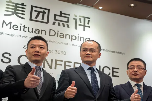 Chen Shaohui, chief financial officer and senior vice president of Meituan Dianping, left, Wang Xing, co-founder and chief executive officer of Meituan Dianping, and Wang Huiwen, senior vice president of Meituan Dianping. (Paul Yeung/Bloomberg)