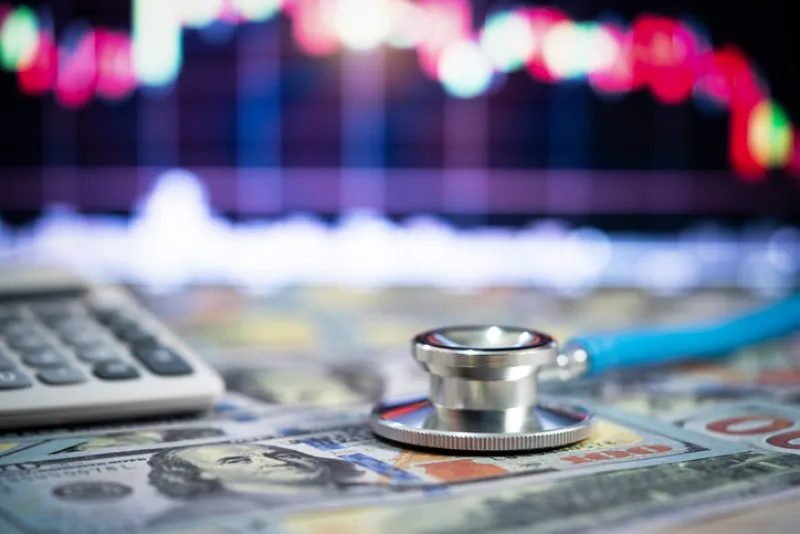 Stethoscope and money,Financial analysis, auditing or accounting - calculator calculators and dollar banknotes