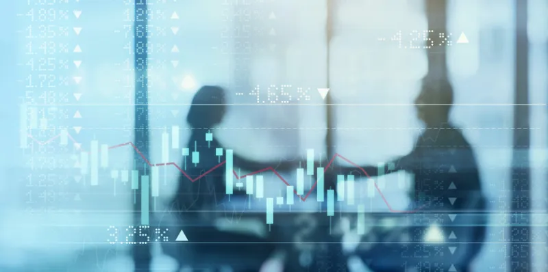 Digitally enhanced shot of a two businesspeople shaking hands in the boardroom superimposed over a graph showing the ups and downs of the stock market