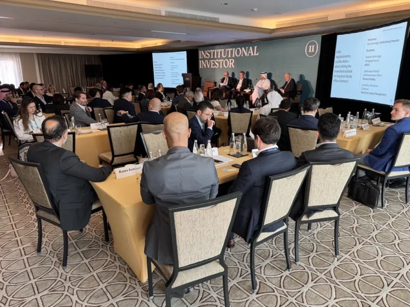 High-angle photo from directly above of an architect, a businessman, and a construction worker examining a blueprint on a construction site.